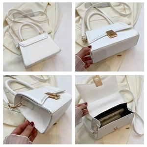 Detailed view of white leather crossbody bag showing lock, woven handle and interior space