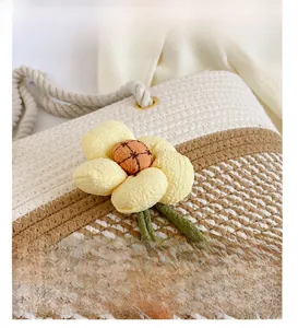 Vue détaillée du sac tissé main avec texture rayée et décoration florale en tissu