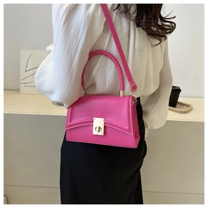 Detail view of pink PU leather crossbody bag with metal lock and woven handle