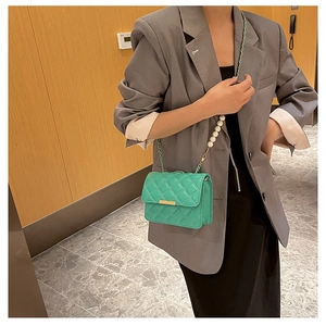 Détail du sac matelassé vert menthe avec élégante bandoulière en perles et métal doré