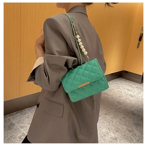 Détail du sac bandoulière matelassé vert menthe avec chaîne perles et boucle dorée