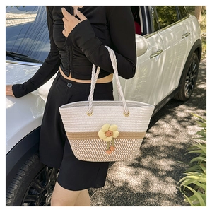 Vue détaillée du sac seau bicolore tressé avec fleur jaune et anses en corde