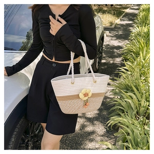 Détail du sac seau tissé main avec fleurs de marguerite et cordes en coton naturel
