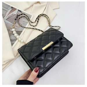 Détail du sac à bandoulière matelassé noir avec chaîne en perles et boucle dorée