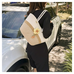 Détail du sac seau tissé à la main avec surpiqûres et breloque en peluche tournesol