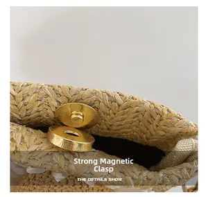 Dettaglio della potente chiusura magnetica su una borsa a tracolla in paglia intrecciata