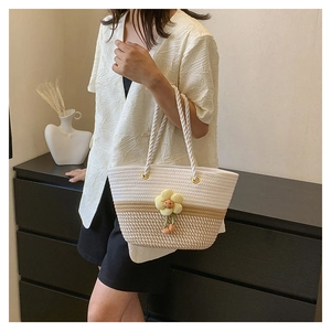 Détail du sac cabas tissé en coton bicolore avec pendentif floral jaune décoratif