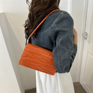 Chic orange crocodile embossed patent leather baguette bag with gold metal accents