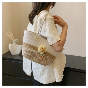 Détail du sac cabas en corde tressée avec rayures contrastées et pendentif fleur