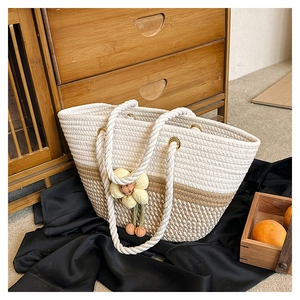 Gros plan du sac en coton tressé bicolore avec pendentif décoratif en forme de fleur jaune