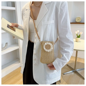 Dettaglio borsa porta cellulare in paglia intrecciata con margherita bianca e tracolla