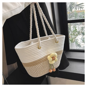Détail du sac seau en coton tressé avec texture bicolore blanc beige et pendentif fleur