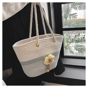Détail d'un sac seau tissé à la main avec corde de coton bicolore crème et gris et fleur