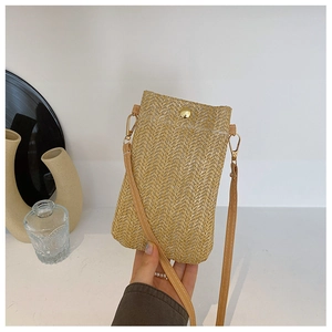 Dettaglio borsa porta cellulare in paglia intrecciata con motivo a spina di pesce e fibbia d'oro
