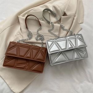 Quilted geometric chain shoulder bags in brown and silver shown with elegant accessories