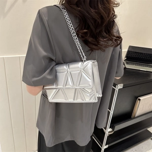 Silver metallic chain bag featuring a geometric triangle quilted design shown on model