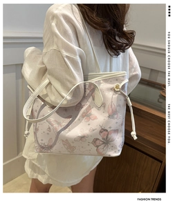 Detail of white butterfly print tote bag with long shoulder strap and tassel accents