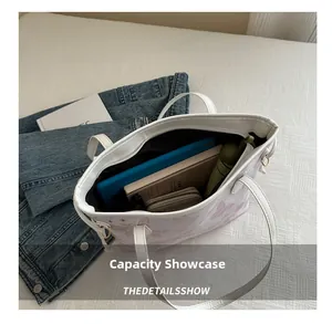 Capacity display of white butterfly tote bag showing tablet, wallet and umbrella