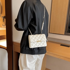 Sac bandoulière matelassé blanc avec détails dorés et chaîne élégante en perles