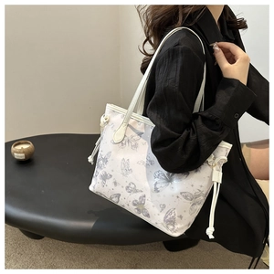Detailed side view of large white butterfly print tote bag with stylish drawstring details