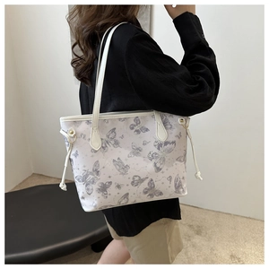 Detail of white tote bag with purple butterfly print and side drawstring ties