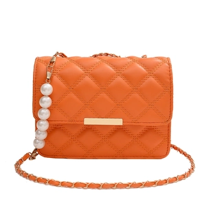 Sac bandoulière orange matelassé avec chaîne dorée et breloque décorative en perles