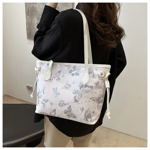 Detail of artistic lavender butterfly prints on a chic cream tote bag for women