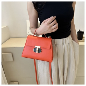 Dettaglio della borsa a tracolla in pelle PU rosso arancio con elegante chiusura dorata