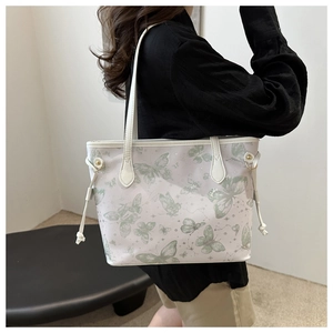 Detail of white tote bag with green butterfly print and adjustable drawstring side