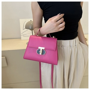 Vista dettagliata della borsa rosso rosa con chiusura a rotazione dorata e texture liscia