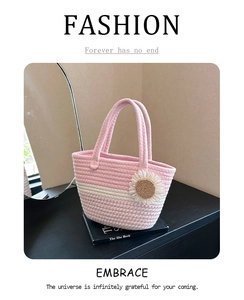 Close-up of pink and white striped woven tote bag with a white daisy floral accessory