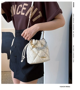 Close-up of white quilted bucket bag with two-tone chain and JINGPIN nameplate