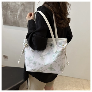Detail view of large butterfly print tote bag with white leather straps and side drawstrings