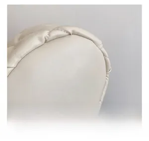 Detailed close-up of beige quilted faux leather texture with neat stitching on a bucket bag