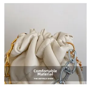 Detail of quilted leather texture and drawstring design on beige bucket bag