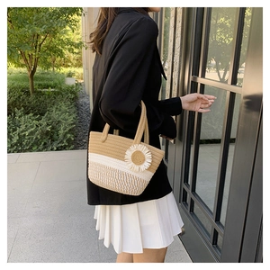 Detail of hand-woven bucket bag featuring a 3D sunflower accent and dual-tone texture