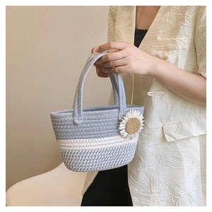 Detail of blue and white hand-woven bag with a large daisy floral applique and sturdy handle
