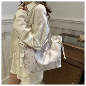 Close-up of white tote bag with pink butterfly prints and side drawstring details