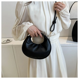 Détails du sac hobo en similicuir noir avec boucle dorée et bandoulière à nœud