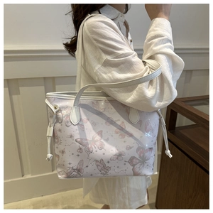 Close-up of white tote bag with pink butterfly prints and side drawstring details