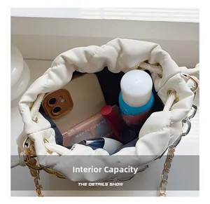 Detail view of large interior storage capacity in a white quilted drawstring bucket bag