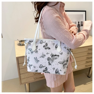 Lifestyle shot of white butterfly print tote bag with side drawstring worn by a model