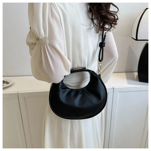 Sac croissant noir minimaliste porté par un mannequin avec détails dorés chics