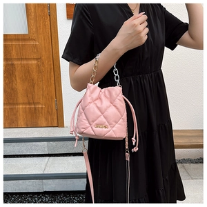 Detail of pink quilted bucket bag with gold JINGPIN logo and bicolor chain strap