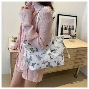 Detail of butterfly print tote bag with white drawstring accents on a casual canvas material