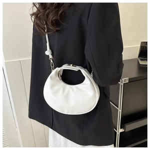 Détail du sac bandoulière demi-lune blanc en cuir PU souple et finitions métalliques dorées
