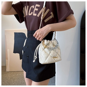 Detail of quilted drawstring bucket bag with dual-tone metal chain and PU leather