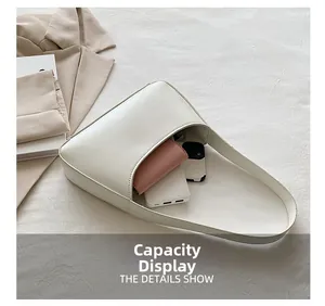 Minimalist white leather underarm bag showing large capacity for phone and wallet