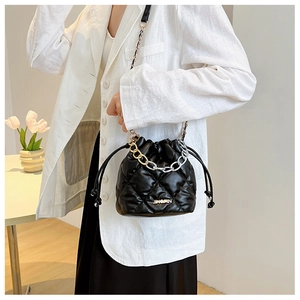 Detail of black quilted bucket bag with JINGPIN metal plate and dual-tone chain