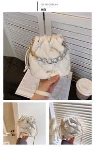 Close-up of off-white quilted bucket bag with stylish gold and silver chain details